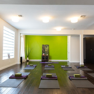 Large contemporary home yoga studio in New York with dark hardwood floors and green walls.