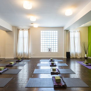 Foto di un grande studio yoga minimal con pareti verdi e parquet scuro