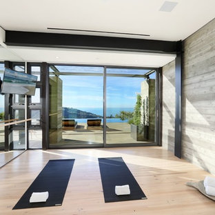 Ispirazione per uno studio yoga contemporaneo di medie dimensioni con pareti grigie, parquet chiaro e pavimento marrone