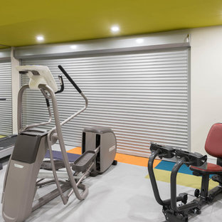 Esempio di una grande sala pesi minimal con pareti bianche, moquette e pavimento multicolore