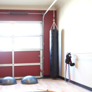 Foto di un piccolo studio yoga minimal con pareti rosse e parquet chiaro