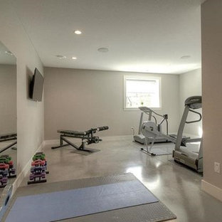 Idee per una grande sala pesi minimalista con pareti beige, pavimento in cemento e pavimento grigio