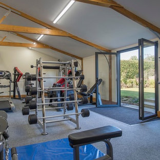 Large farmhouse home weight room in Other with beige walls, carpet and grey floors.