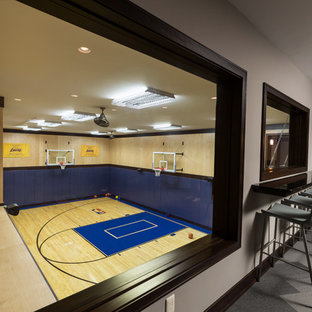Idee per un grande campo sportivo coperto tradizionale con parquet chiaro e pareti grigie