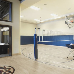 Immagine di un grande campo sportivo coperto classico con pareti bianche e parquet chiaro
