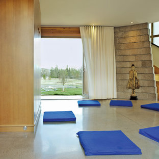 Moderner Yogaraum mit beiger Wandfarbe und Betonboden in Denver