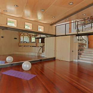 Foto di uno studio yoga rustico con parquet scuro e pavimento rosso