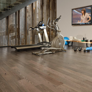 Esempio di una grande palestra multiuso minimalista con pavimento in legno massello medio e pareti marroni