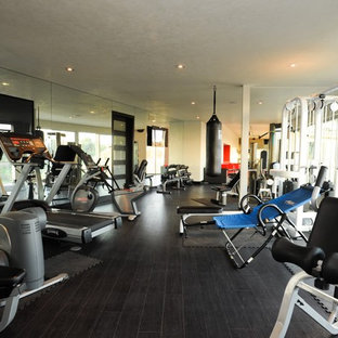 Immagine di una palestra in casa minimalista con pavimento nero