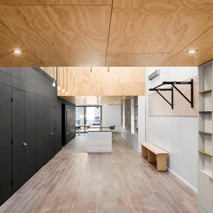 Ispirazione per una grande sala pesi minimal con pareti bianche, pavimento in legno massello medio e pavimento multicolore