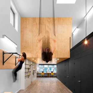 Idee per una grande sala pesi contemporanea con pareti bianche, pavimento in legno massello medio e pavimento multicolore