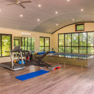 Inspiration for a large tropical multipurpose gym in Sunshine Coast with beige walls and brown floor.