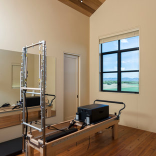 Ispirazione per una grande palestra multiuso country con pareti bianche e pavimento in legno massello medio