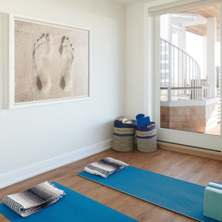 Foto di uno studio yoga stile marinaro di medie dimensioni con pareti bianche, pavimento in laminato e pavimento marrone