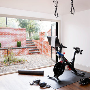 Idee per una palestra in casa classica con pareti bianche, parquet scuro e pavimento marrone