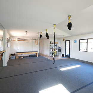 Idée de décoration pour une salle de sport minimaliste multi-usage et de taille moyenne avec un mur blanc et un sol gris.