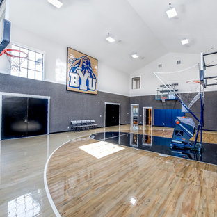 Foto di un ampio campo sportivo coperto chic con pareti grigie, pavimento beige e parquet chiaro