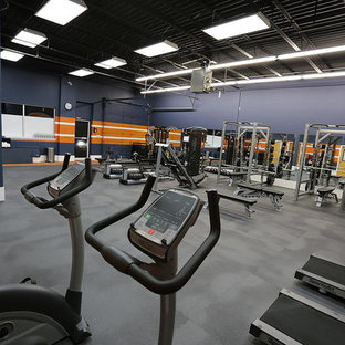 Idée de décoration pour une grand salle de musculation avec un mur bleu.