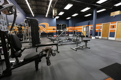 Example of a mid-sized home weight room design in DC Metro with blue walls