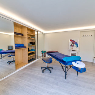 Esempio di una palestra multiuso moderna di medie dimensioni con pareti beige, parquet chiaro e pavimento marrone