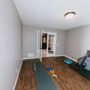 Multifunktionaler, Mittelgroßer Klassischer Fitnessraum mit grauer Wandfarbe, braunem Holzboden und braunem Boden in Omaha