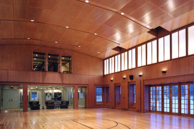Пример оригинального дизайна: большой спортзал в классическом стиле с светлым паркетным полом