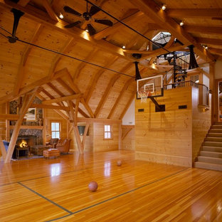 Immagine di un ampio campo sportivo coperto country con pavimento in legno massello medio e pareti marroni