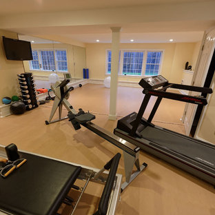 Ispirazione per una grande palestra multiuso chic con pareti gialle, parquet chiaro e pavimento beige