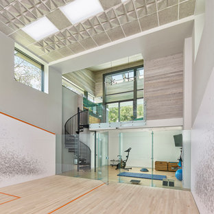 Immagine di un campo sportivo coperto contemporaneo di medie dimensioni con pareti grigie, parquet chiaro e pavimento beige