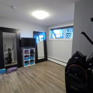 Esempio di una palestra multiuso tradizionale di medie dimensioni con pareti grigie, pavimento in laminato e pavimento marrone