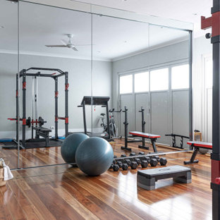 Design ideas for a large contemporary multipurpose gym in Sydney with white walls, medium hardwood floors and brown floor.