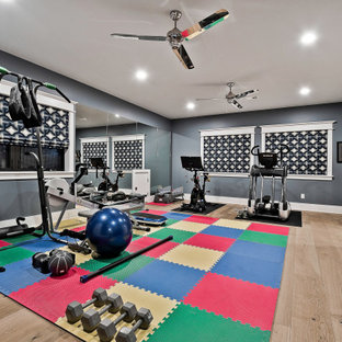 Foto di una grande palestra multiuso minimalista con pareti blu e parquet chiaro