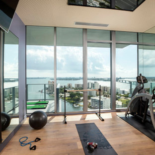 Cette photo montre une salle de musculation tendance de taille moyenne avec un sol marron.