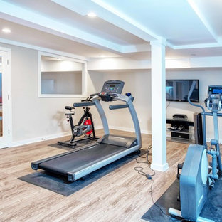 Idee per una grande palestra multiuso contemporanea con pareti grigie, pavimento in laminato e pavimento marrone