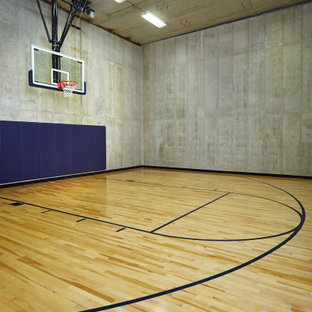 Geräumiger Moderner Fitnessraum mit Indoor-Sportplatz, grauer Wandfarbe und hellem Holzboden in Grand Rapids