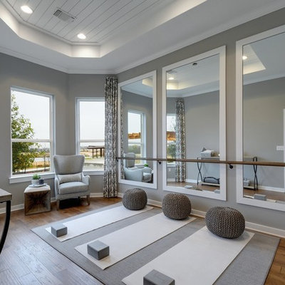 Example of a transitional medium tone wood floor and brown floor home yoga studio design in Jacksonville with gray walls