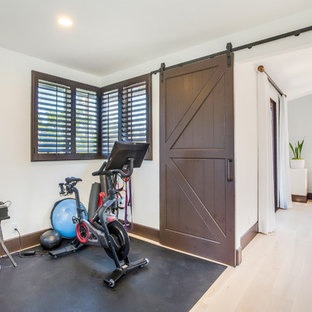 Foto di una piccola palestra multiuso mediterranea con pareti bianche, parquet chiaro e pavimento beige