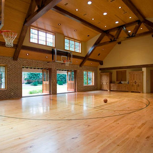 Foto di un ampio campo sportivo coperto classico con pareti gialle e parquet chiaro