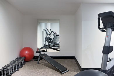 Imagen de gimnasio multiusos minimalista de tamaño medio con paredes blancas, suelo de linóleo y suelo beige