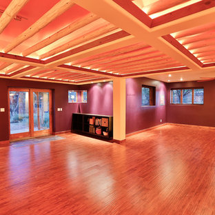 Immagine di un grande studio yoga rustico con pareti viola, pavimento in legno massello medio e pavimento marrone
