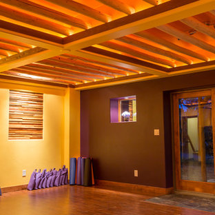 Großer Uriger Yogaraum mit lila Wandfarbe, braunem Holzboden und braunem Boden in Denver