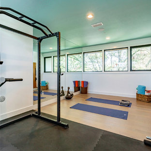 Immagine di un grande studio yoga classico con pareti blu, pavimento in legno massello medio e pavimento beige