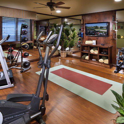Example of a tuscan medium tone wood floor and brown floor home gym design in Denver with green walls