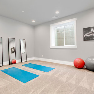 Immagine di un grande studio yoga tradizionale con pareti grigie, moquette e pavimento beige