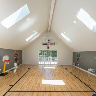 Immagine di un campo sportivo coperto chic con pareti grigie e parquet chiaro