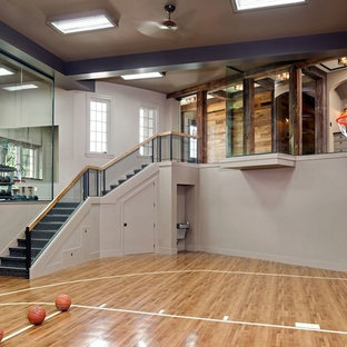 Foto di un campo sportivo coperto classico con pareti grigie, pavimento in legno massello medio e pavimento beige
