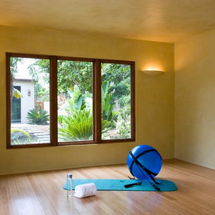 Idee per uno studio yoga tropicale di medie dimensioni con pareti beige, parquet chiaro e pavimento beige