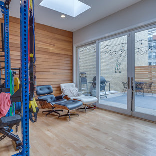 Ispirazione per una piccola sala pesi moderna con pareti bianche, parquet chiaro e pavimento beige