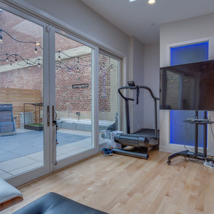 Immagine di una piccola sala pesi minimalista con pareti bianche, parquet chiaro e pavimento beige
