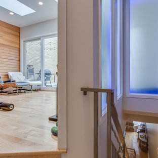 Immagine di una piccola sala pesi minimalista con pareti bianche, parquet chiaro e pavimento beige